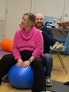 A practical teaching session at a Midwives for Mothers antenatal class in Bristol, demonstrating the use of peanut balls during labour